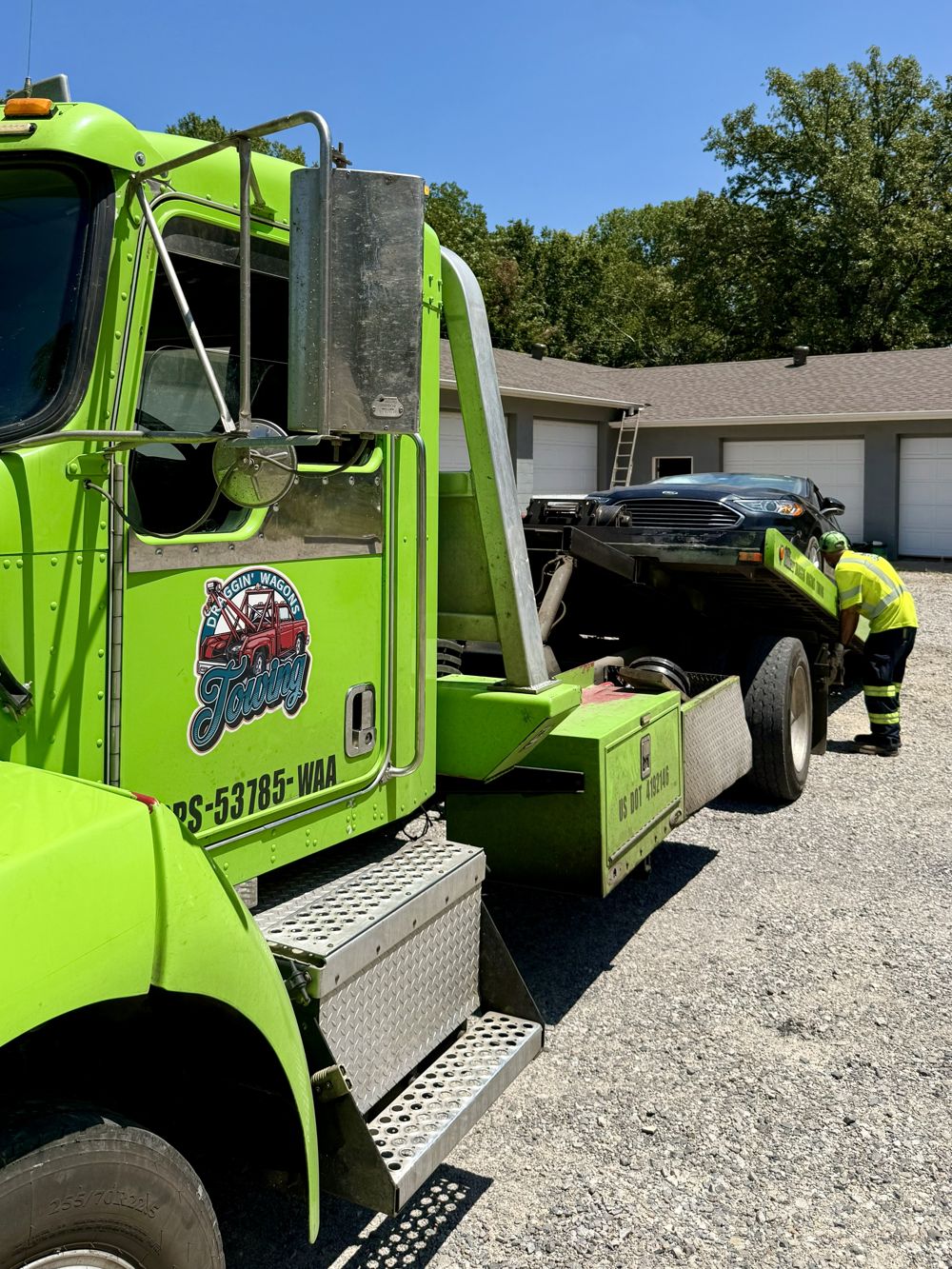 Draggin' Wagons Towing crew member loading a vehicle onto the flatbed wrecker