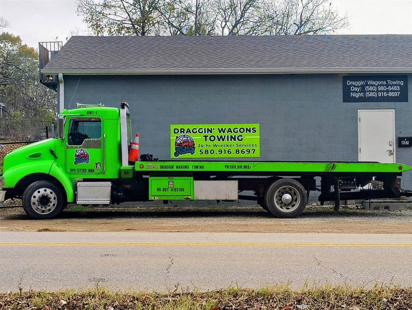 Draggin' Wagons Towing green flatbed tow truck parked at the Durant, OK shop
